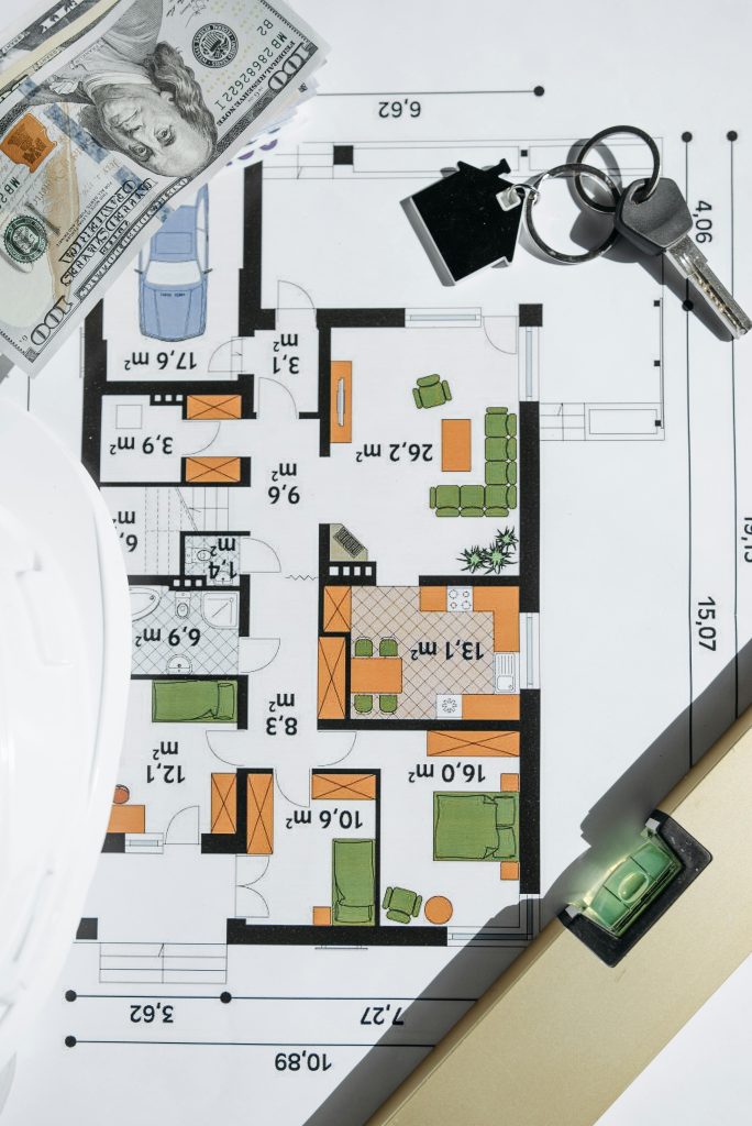 Overhead view of a house floor plan with keys and cash, symbolizing real estate investment. Vue aérienne d'un plan d'étage de maison avec des clés et de l'argent, symbolisant l'investissement immobilier.