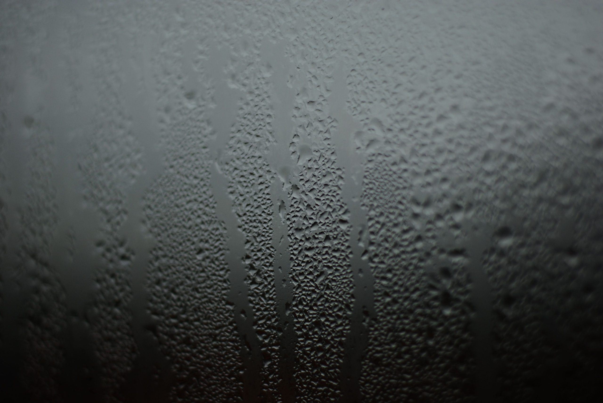 Gouttelettes d'eau formant des motifs sur fenêtre