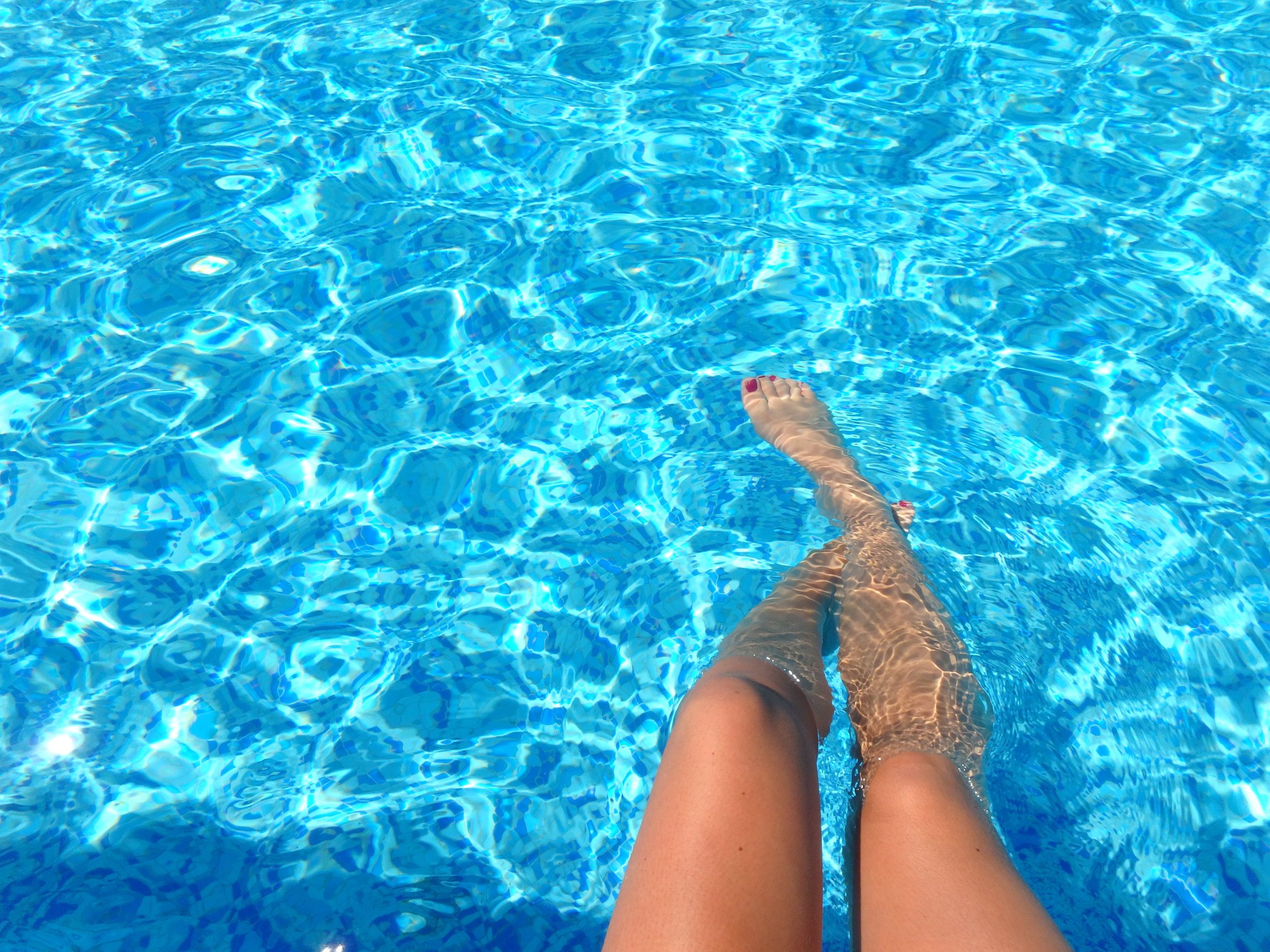 Personne se détend dans piscine eau bleue cristalline