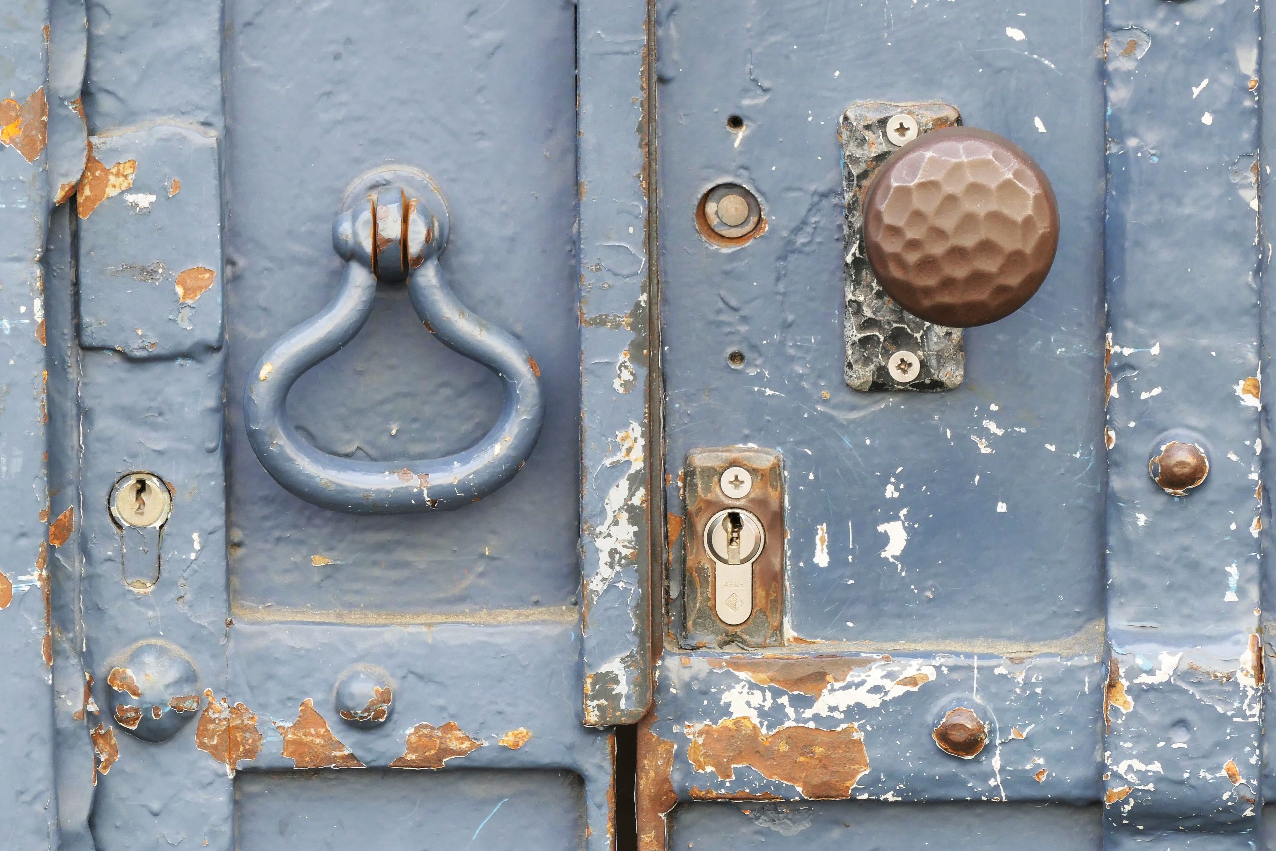 Vieille serrure rouillée sur porte bleue usée