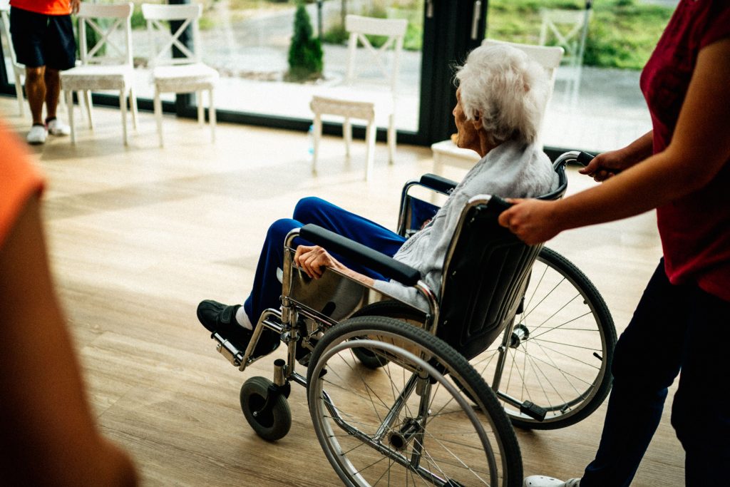 Aide-soignante assistante personne âgée en fauteuil
