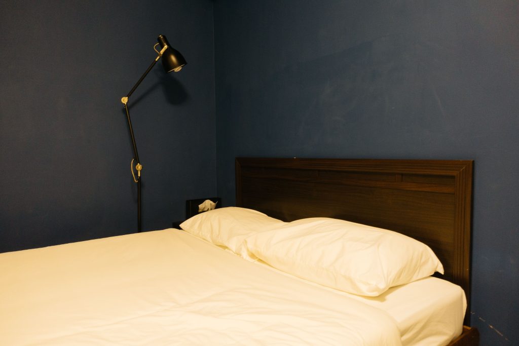 Chambre minimaliste avec mur bleu foncé et lampe