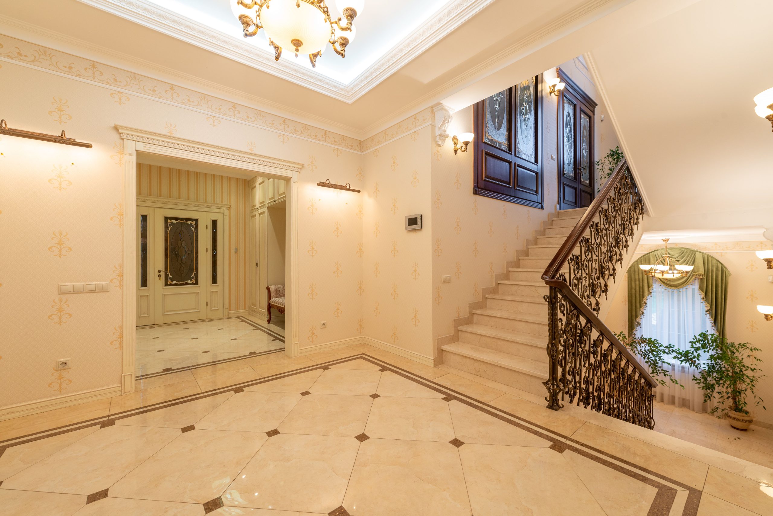 Intérieur spacieux avec grand escalier et lustre