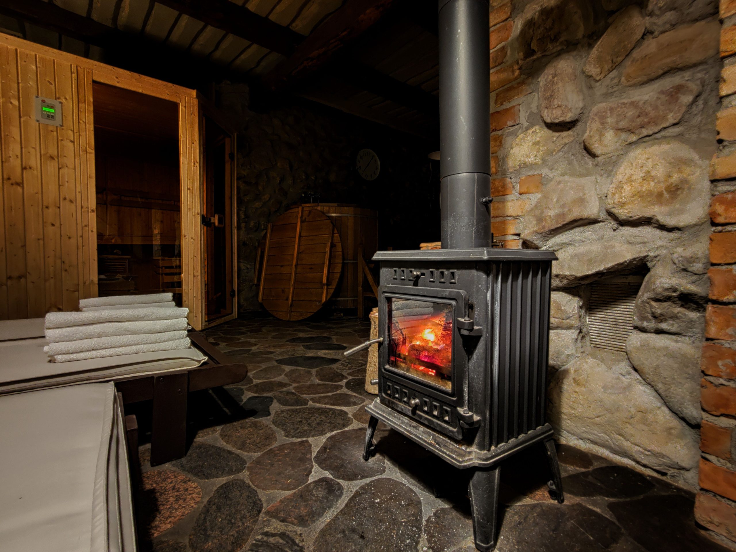 Sauna rustique avec poêle à bois et murs en pierre