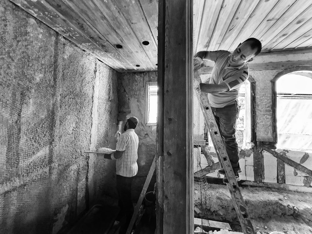 Deux hommes rénovent une pièce ensemble avec plâtre