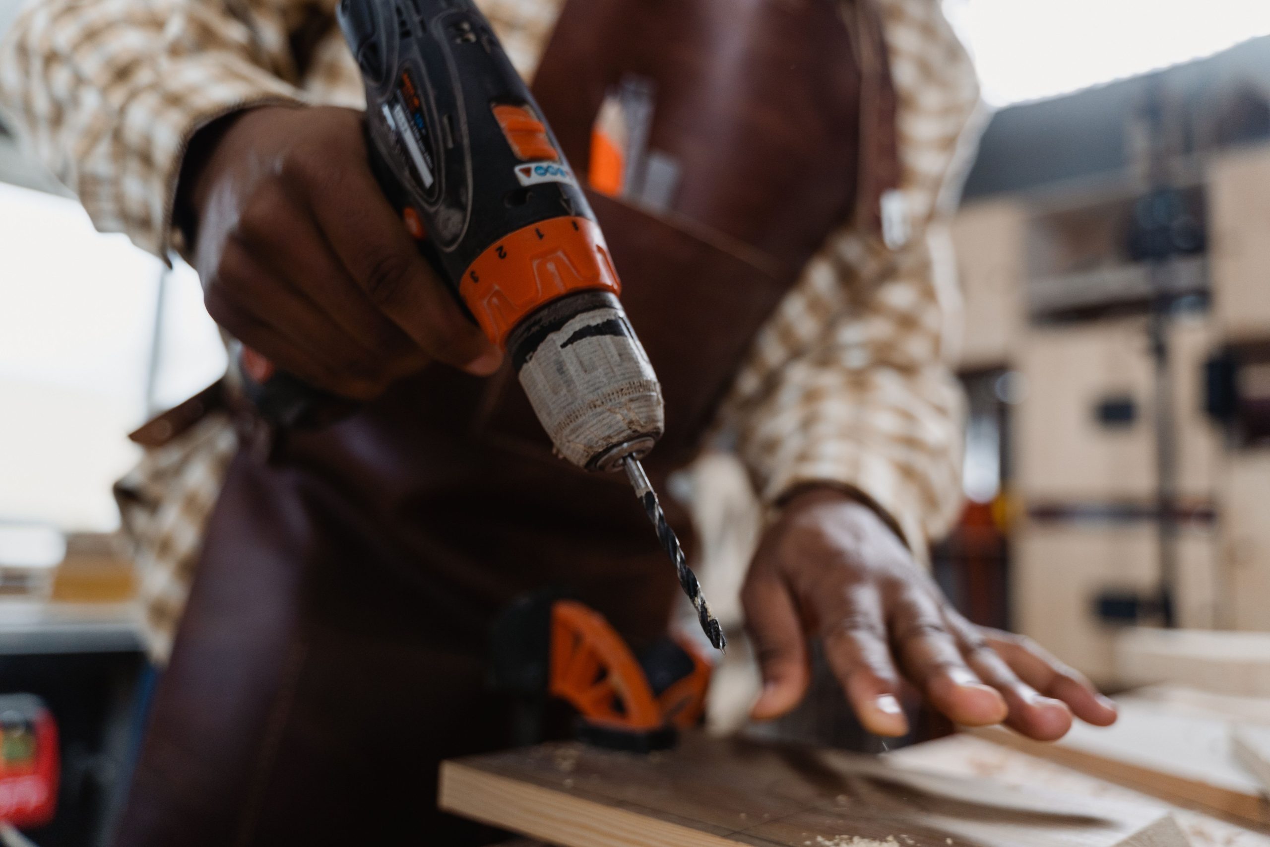 Artisan utilise visseuse sur planche bois