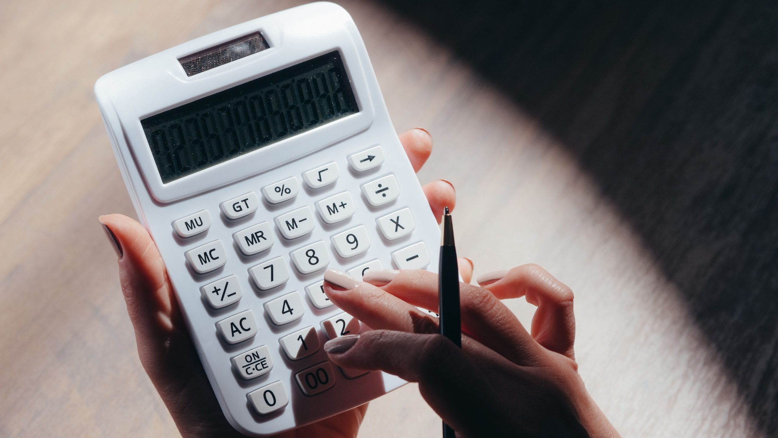 Mains calculant budget avec calculatrice et stylo