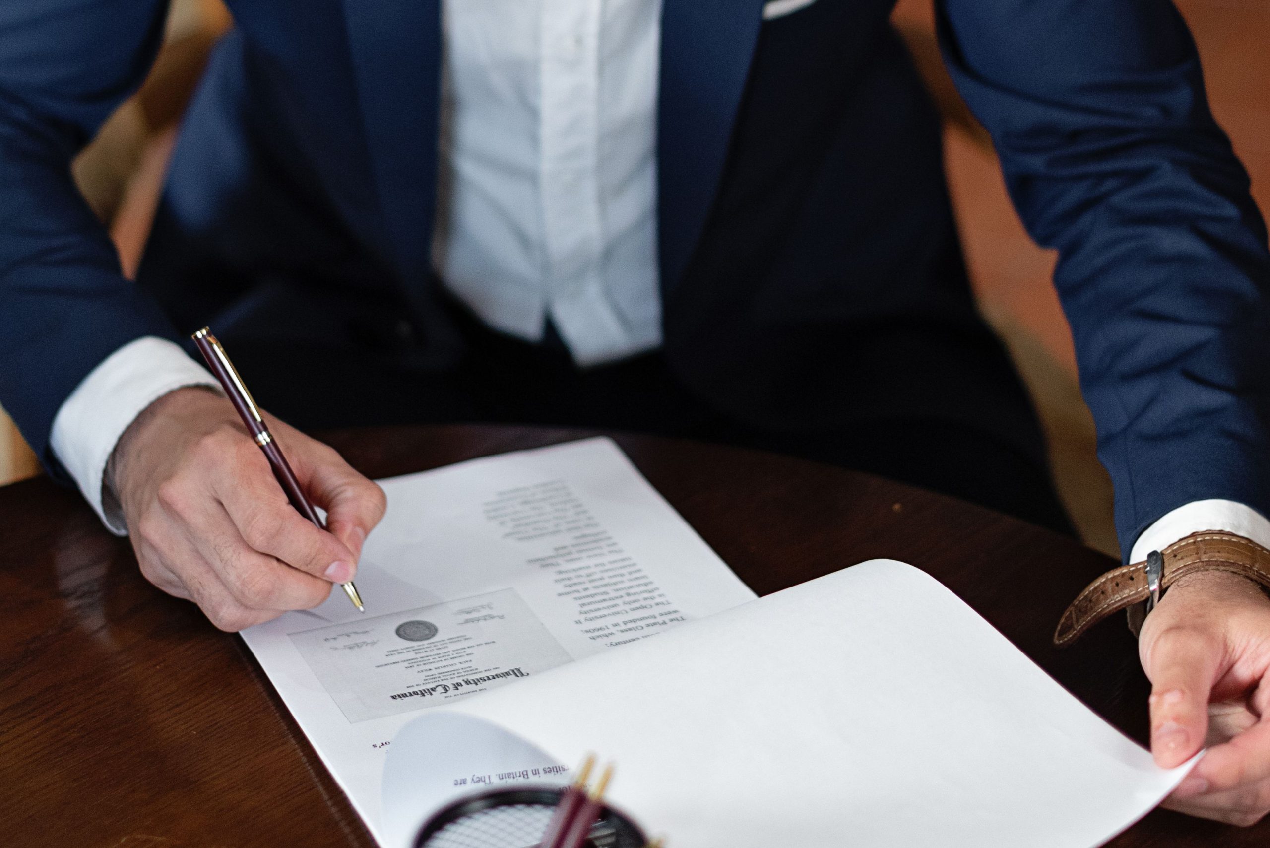 Professionnel signe documents juridiques bureau