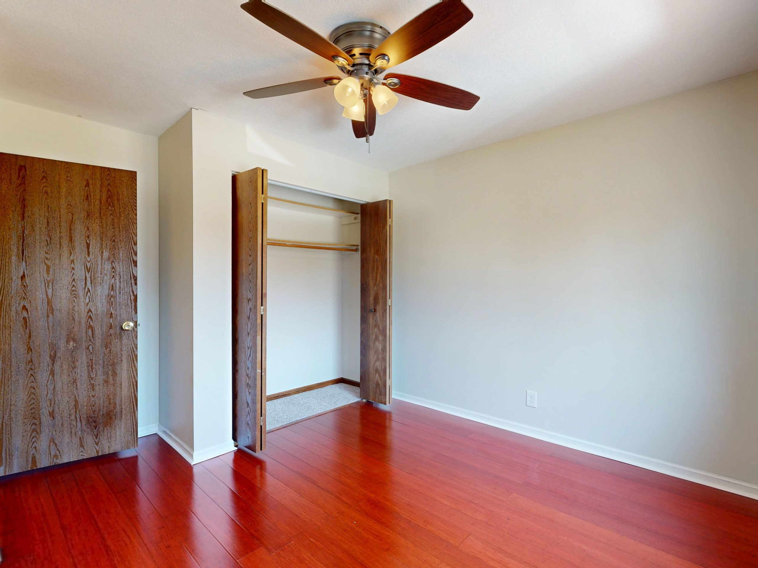 Pièce spacieuse avec parquet et placard ouvert