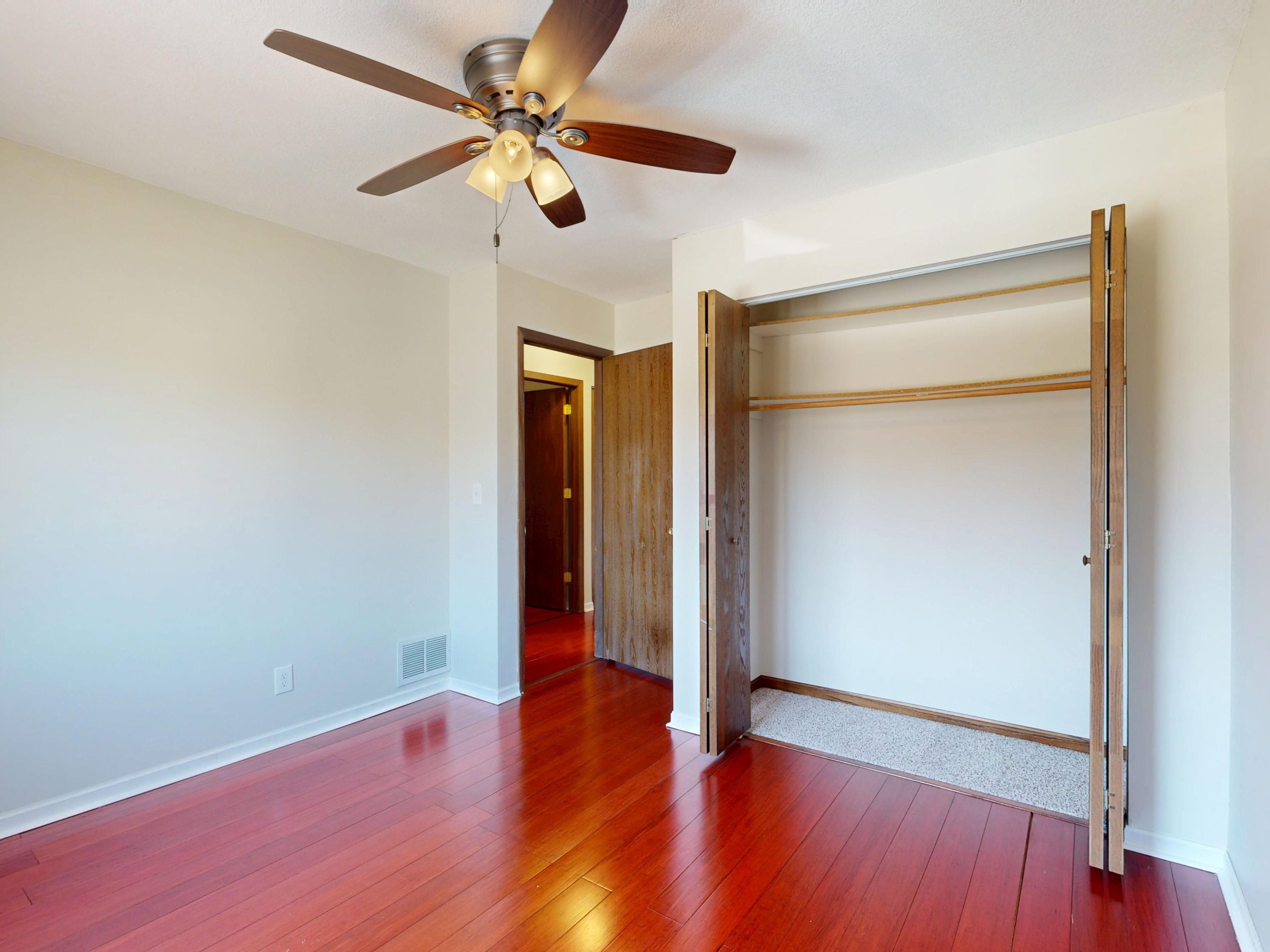 Pièce vide avec parquet et ventilateur de plafond